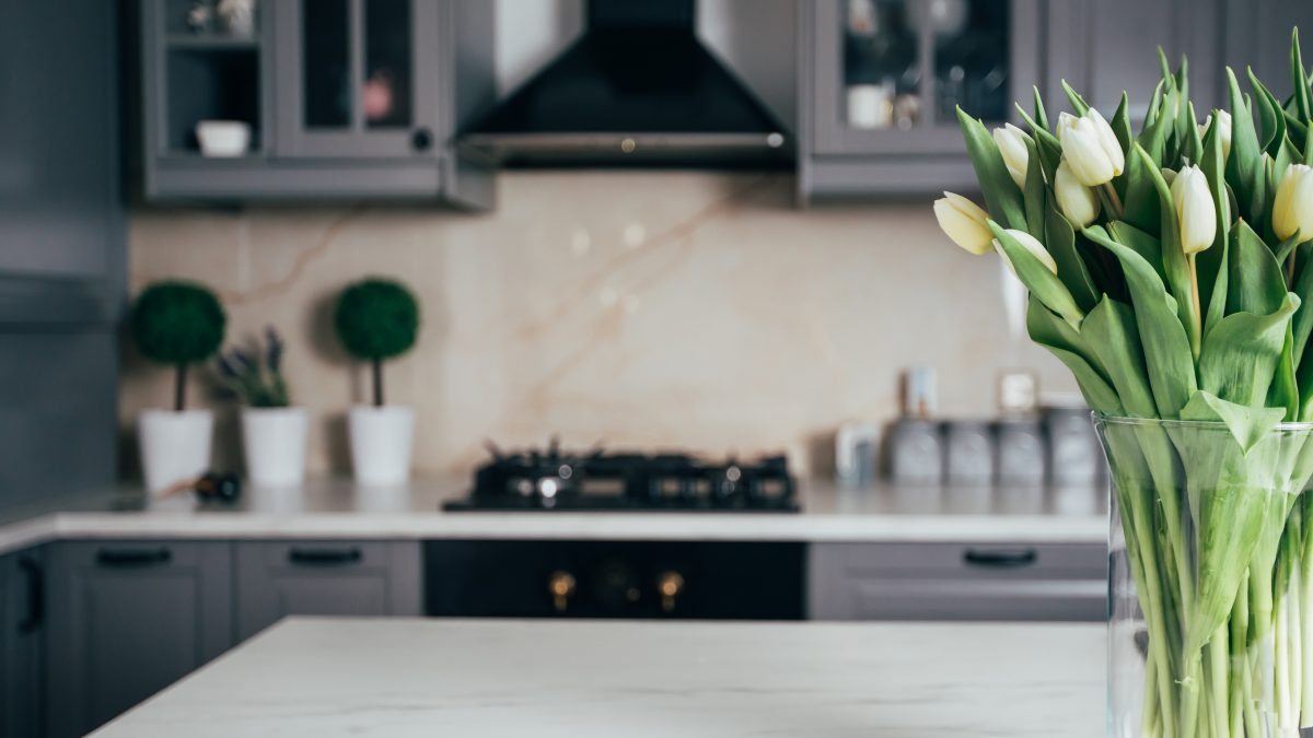 grey and white kitchen with yellow tulips in a vase on counter